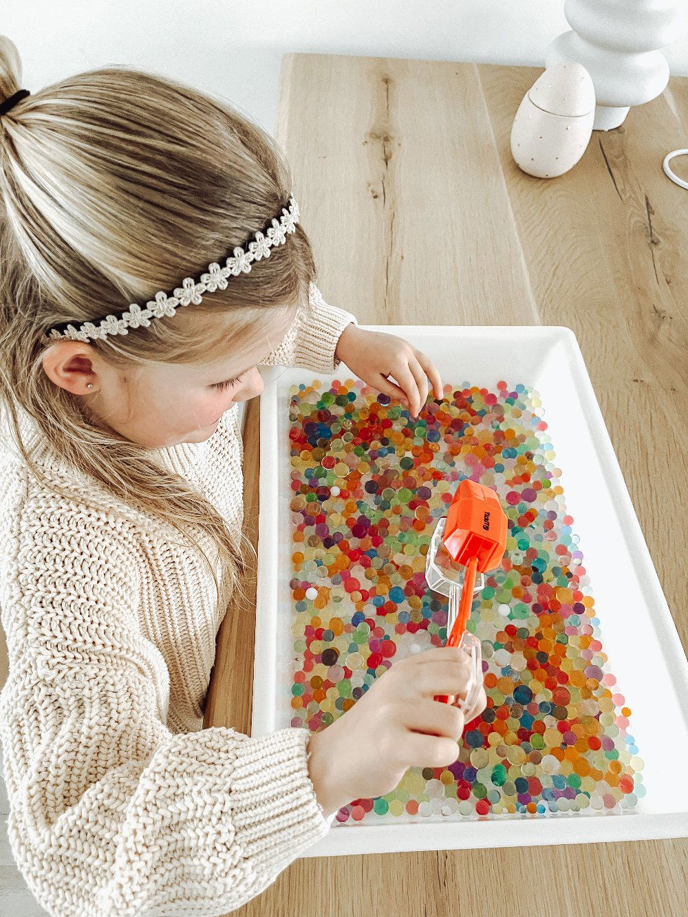 Gekleurde grijper - yourlittlefamily-nl - Gekleurde grijper wordt vastgehouden door meisje die aan het spelen is met waterparels