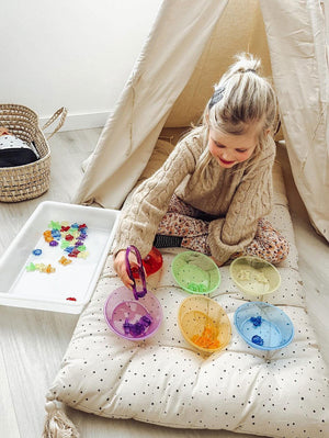 Gekleurde insecten 48 stuks - yourlittlefamily-nl - Meisje is met een pincet de gekleurde insecten in het gekleurde bakje te doen. Kleuren leer en sensomotorisch spel